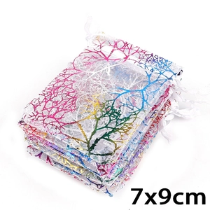 Primer plano de bolsas de regalo de organza blanca 7x9cm con estampados de ramas doradas