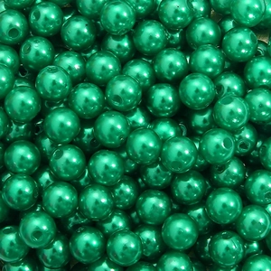 Macro shot of metallic dark green round acrylic beads with holes for DIY jewelry