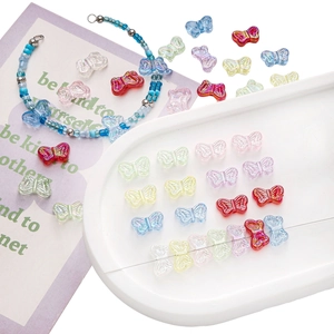 DIY jewelry making scene with colorful acrylic butterfly beads in pastel shades on a tray