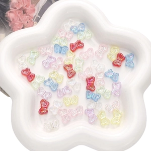Macro shot of colorful iridescent butterfly acrylic beads in a white ceramic star tray