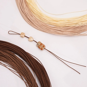 Macro detail of 1mm waxed polyester cord with ceramic beads for DIY jewelry making