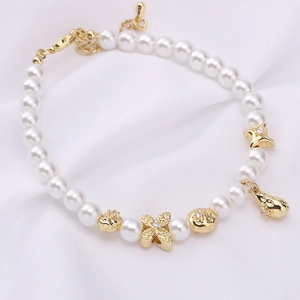 Makro-Detail von 14K vergoldetem Perlenarmband mit Perlen und Blumenanhängern