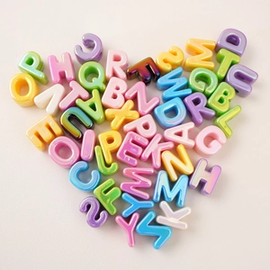 Makro-Detail von 26 bunten Acryl-Buchstabenperlen in Herzform für DIY-Schmuck