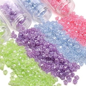 Macro-opname van gekleurde bloemvormige kralen in transparante buisjes voor DIY-sieraden