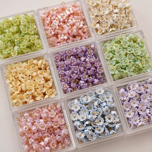 Macro view of colorful resin lily flower charms with gold loops for DIY jewelry making