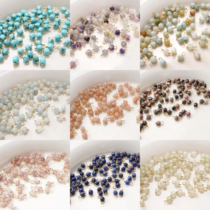 Macro shot of assorted 4mm faceted natural stone cube charms with gold loops for DIY jewelry