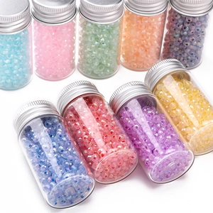 Detailed view of 4mm colorful multifaceted glass beads in small clear glass bottles