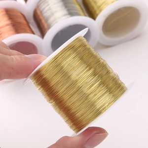 Spool of shiny golden copper jewelry wire for DIY handmade craft projects and jewelry making