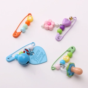 Set of four colorful painted iron safety pins with heart pendants and decorative beads