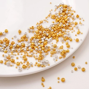 Macro shot of 2-3mm gold and silver metallic seed beads for DIY jewelry making
