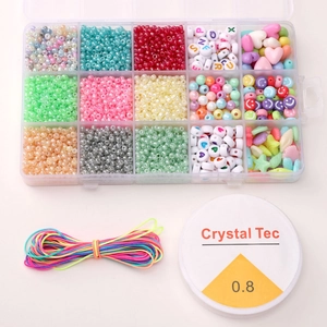 Vue macro de la boîte à 15 cases avec perles colorées et kit de bijoux DIY
