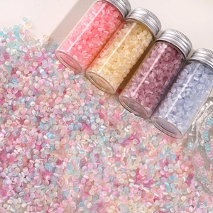 Macro detail of 4x2.5mm pastel glass seed beads in small glass vials for DIY jewelry making