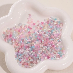 Macro shot of 4mm pearlized glass cat eye beads in a white flower tray for DIY jewelry