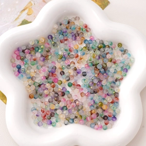 Macro shot of colorful 4mm frosted glass beads with gold foil inside a petal tray