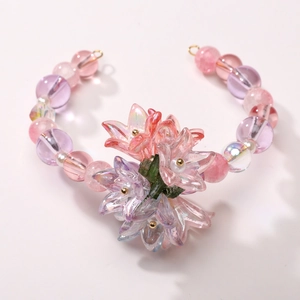 Detailed top view of handmade beaded bracelet with acrylic lily flowers and pearls