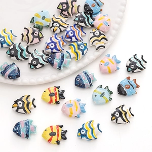 Close-up of colorful hand-painted fish-shaped ceramic beads for DIY jewelry making