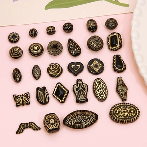 Detail of vintage acrylic beads with gold relief patterns for DIY jewelry making