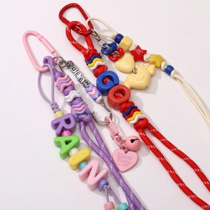 Macro shot of Y2K style colorful acrylic letter beads and charms on braided lanyards