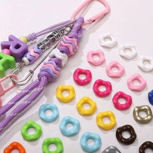 Macro view of colorful acrylic flower beads and purple cord for DIY jewelry crafts