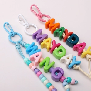 Close-up of colorful handmade beaded keychains with vibrant plastic carabiners and letter beads