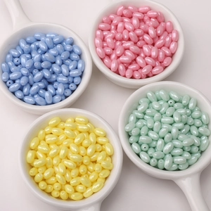 Macro shot of 4x7mm pastel glass rice beads in ceramic bowls for DIY jewelry making