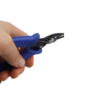 Close-up of blue handle precision pliers holding a gold bead for jewelry DIY crafting