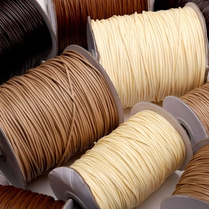 Detail of colorful waxed cords for DIY jewelry making on white spools for bracelets
