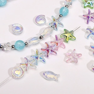 Dettaglio macro di perle in vetro a forma di stella marina e conchiglia per gioielli