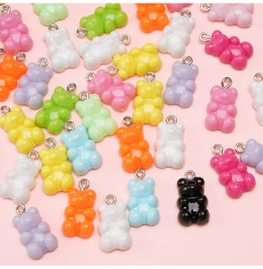 Flat lay of colorful 11x21mm acrylic bear pendants with metal rings for DIY jewelry making
