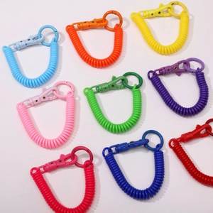 Macro shot of colorful plastic spiral keychains showing elastic spring and carabiner detail
