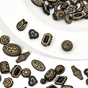 Makroaufnahme von französischen Vintage-Acrylperlen mit Goldmuster für DIY-Schmuck