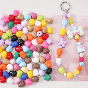 Dettaglio di perline acriliche colorate con accessorio portachiavi Pingu fai-da-te