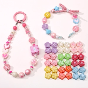 Detailed flat lay of colorful acrylic flower beads and handmade DIY beaded jewelry set