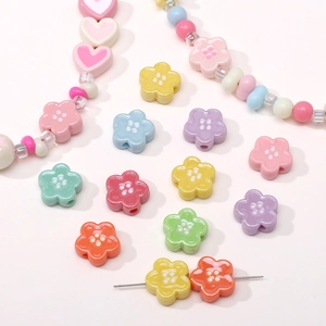 Macro view of colorful macaron acrylic flower and heart-shaped DIY craft beads