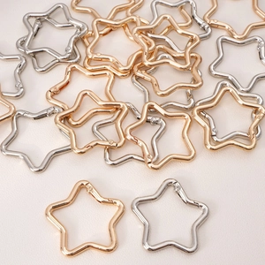 Macro detail of star-shaped metal clasps in gold and silver for DIY keychains