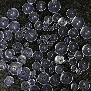 Various sizes of transparent round 2-hole plastic buttons for shirts and DIY crafts