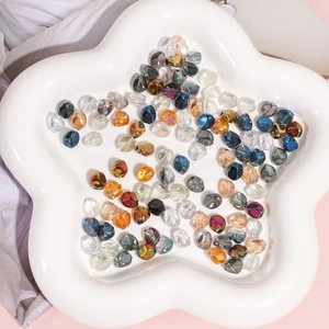 Faceted glass oval beads in mixed colors displayed on a star-shaped tray for DIY jewelry