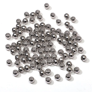 Close-up of polished silver round metal spacer beads with holes for DIY jewelry making