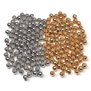 Close-up of polished gold and silver metal round beads with center hole for DIY jewelry