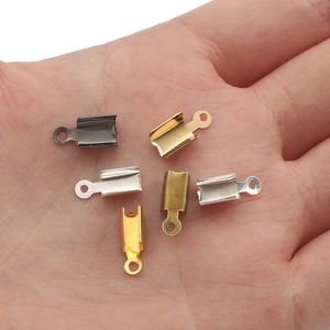 Assorted metal cord end crimps for DIY jewelry making held in palm for scale
