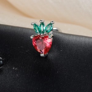 Macro shot of strawberry-shaped stud with heart-cut red stone and marquise green gems