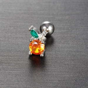Macro shot of fruit-shaped stud earring with orange and green zircon stones