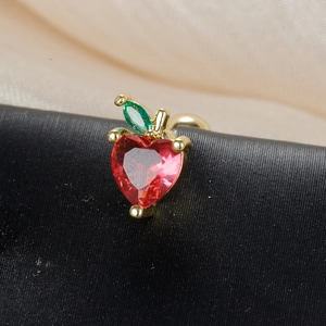 Macro shot of red heart-shaped crystal apple earring with gold setting and green leaf
