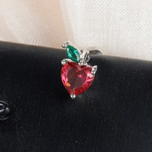 Macro view of crystal cherry fruit earring with red heart stone and green leaf detail