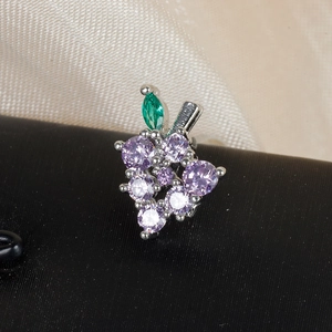 Macro shot of grape-shaped stud earring with purple, white, and green cubic zirconia