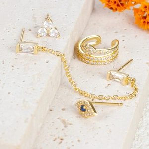 Detailansicht der Evil Eye Ohrringe mit Goldketten und blauen Steinen auf Steinbasis