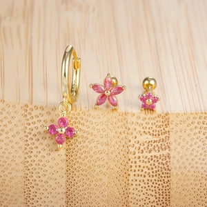 Dettaglio di orecchini S925 in oro con stelle in zircone rosa e ciondoli a fiori