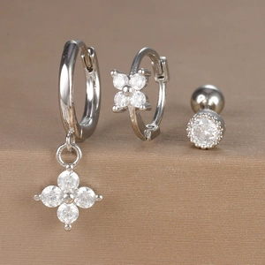 Detailed view of silver hoop earrings set featuring flower charms and clear cubic zirconia