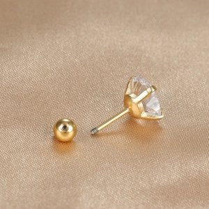 Macro shot of gold-plated screw back heart stud earring with clear cubic zirconia stone