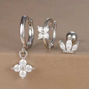Detailed view of three-piece silver zircon earring set with flower and crown charms